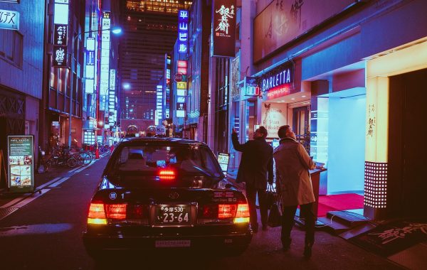 示例专题配图：深夜城市街道霓虹倒映在积水里，一名行人背影走向远处，氛围孤独